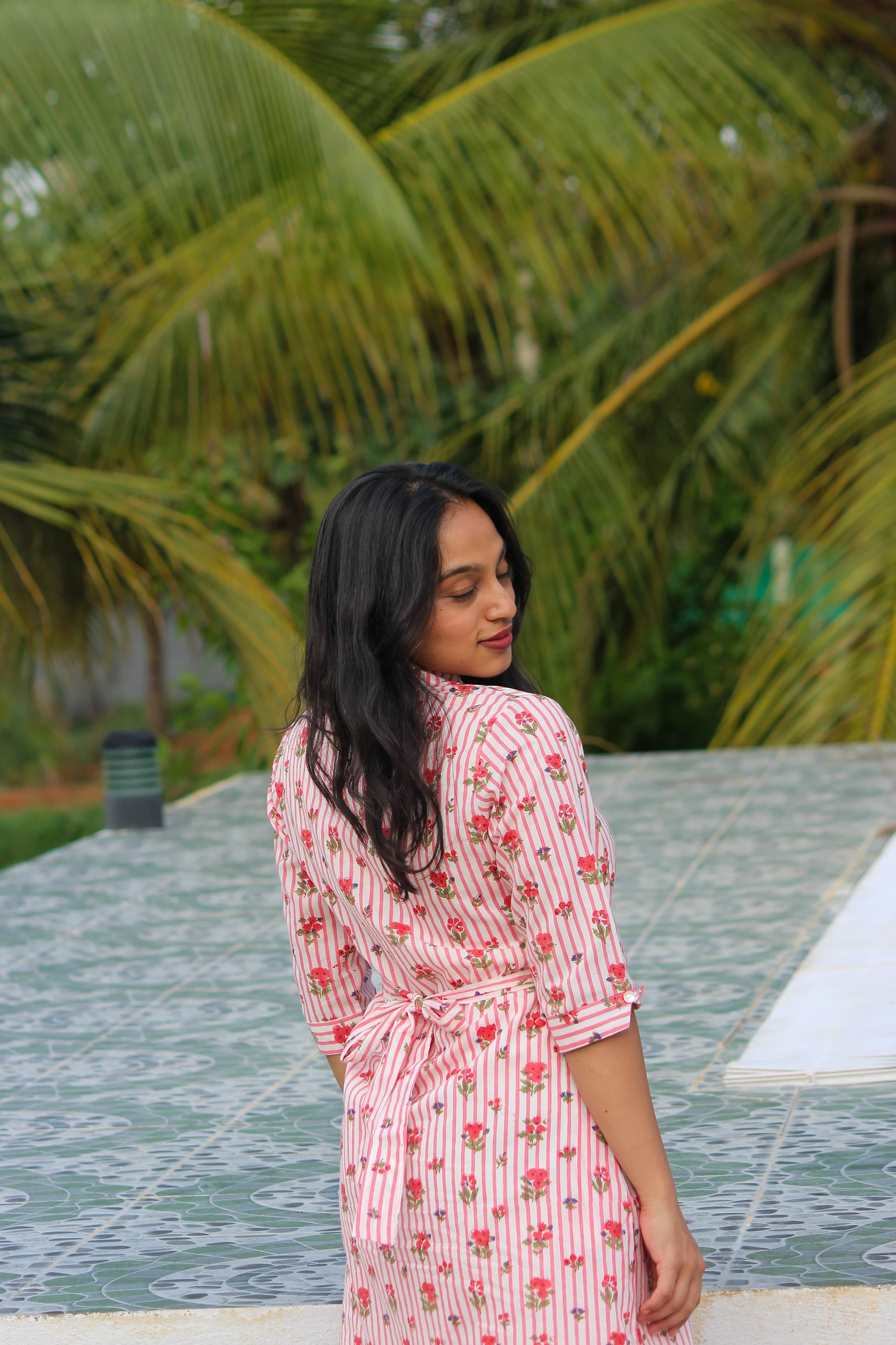 Bimba Studio Rose breathable cotton shirt dress featuring a floral print, functional pockets, and waist tie