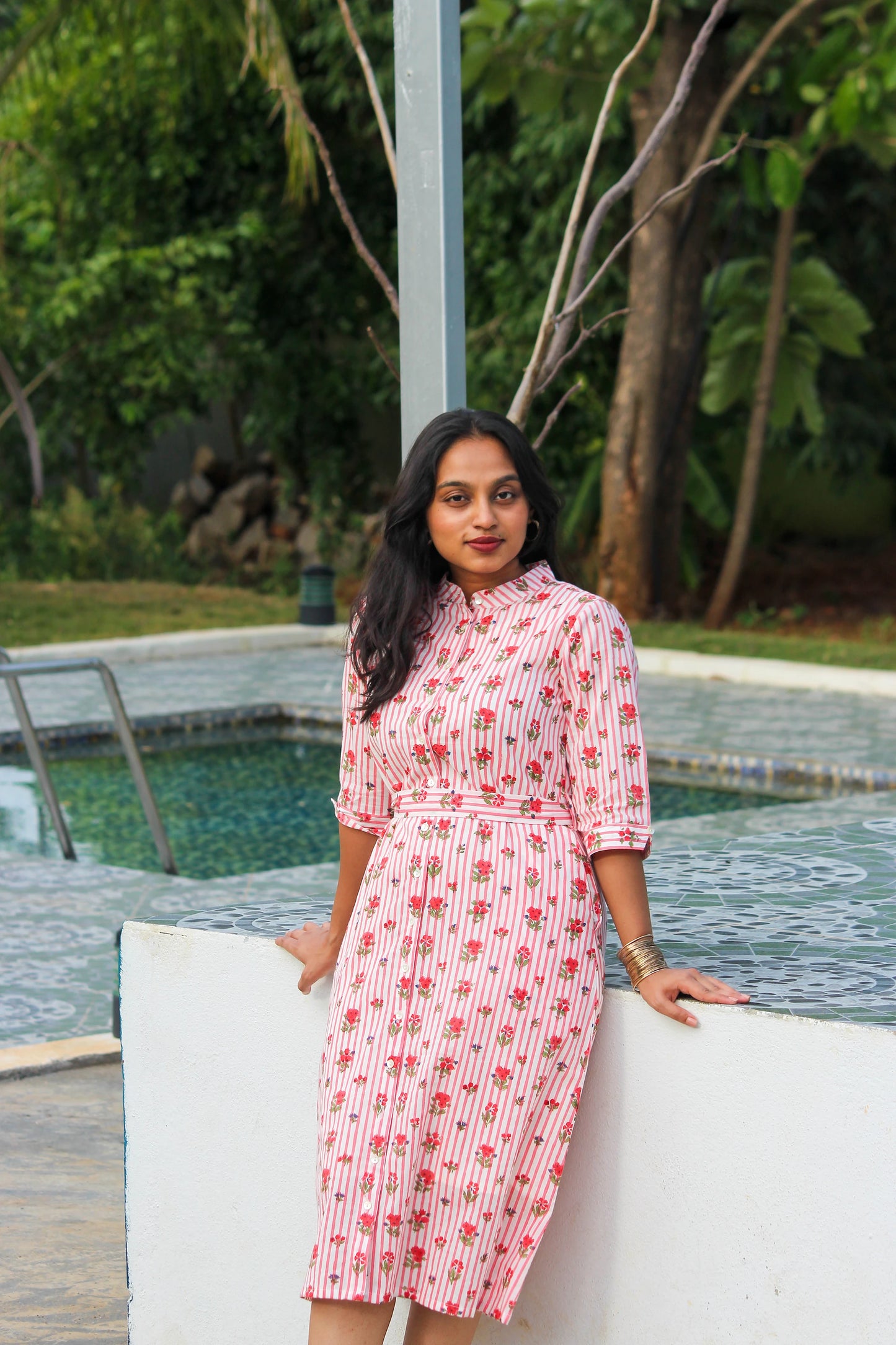 Bimba Studio Rose breathable cotton shirt dress featuring a floral print, functional pockets, and waist tie